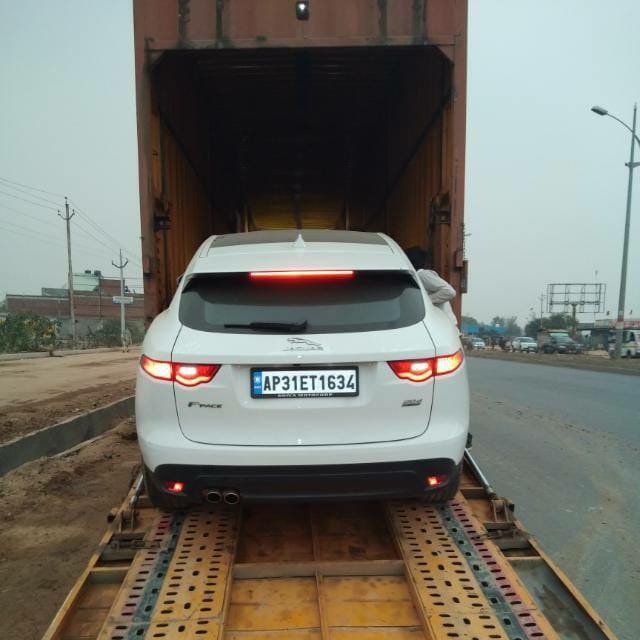 A white car is loding in car carrier by car transport service in Koramangala Bangalore.